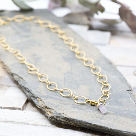 Diese Halskette "Crystal Rose" ist aus Messing und 24k vergoldet. Der Anhänger ist eine Rosenquarz Steinspitze.