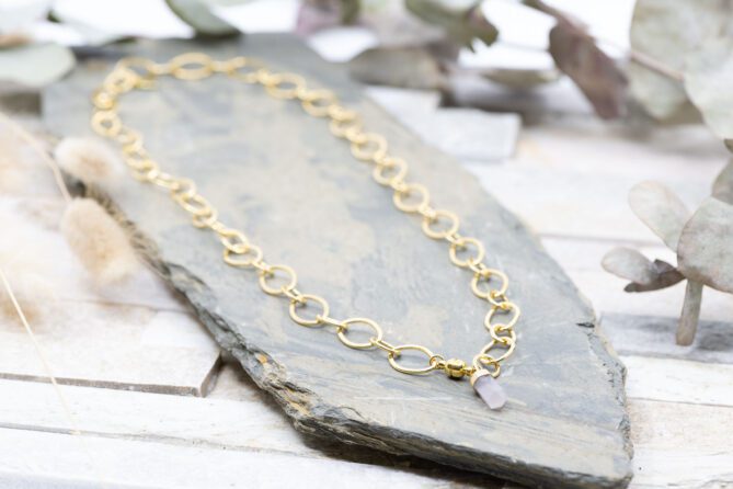 Diese Halskette "Crystal Rose" ist aus Messing und 24k vergoldet. Der Anhänger ist eine Rosenquarz Steinspitze.